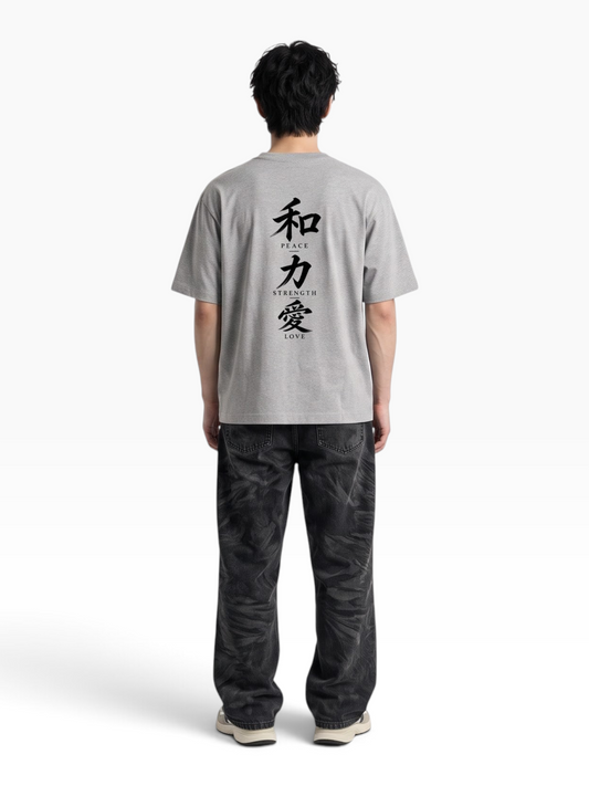 E7 unisex oversized grey cotton t-shirt with Japanese kanji and English text print on the back, worn by a man
