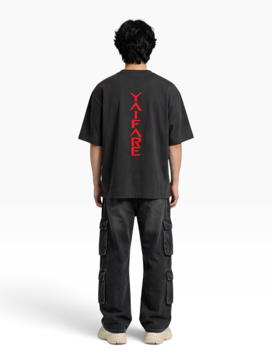 E7 unisex oversized black cotton t-shirt with red vertical back graphic, worn by a model from the back view