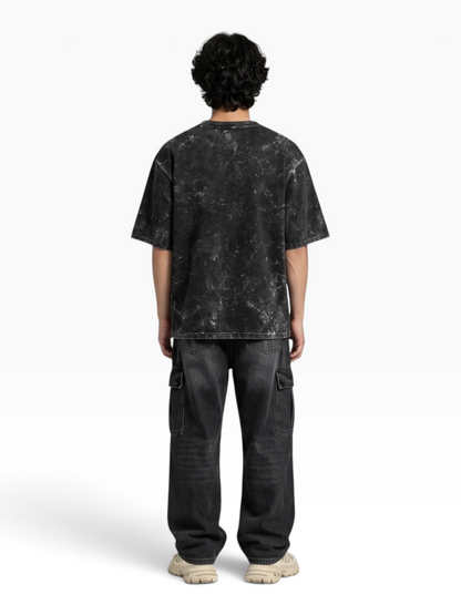 Back view of a person wearing an E7 unisex oversized heavyweight cotton t-shirt with a black acid-washed finish.