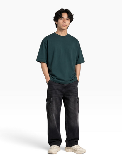 E7 unisex oversized dark green heavyweight cotton t-shirt worn by a man with black cargo pants and sneakers