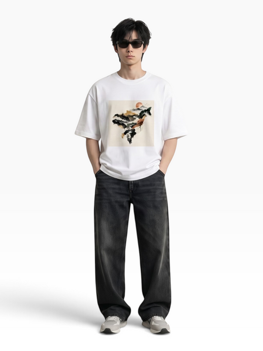 E7 unisex white oversized cotton t-shirt with a mountain graphic print worn by a man with sunglasses and black jeans